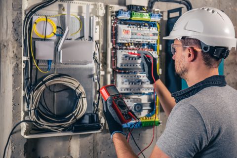 électricien qui cherche une panne sur un tableau électrique