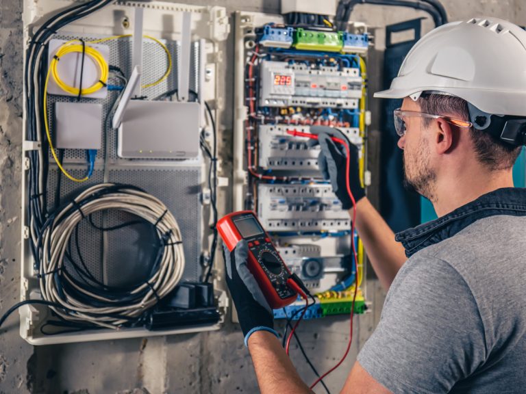 électricien qui cherche une panne sur un tableau électrique